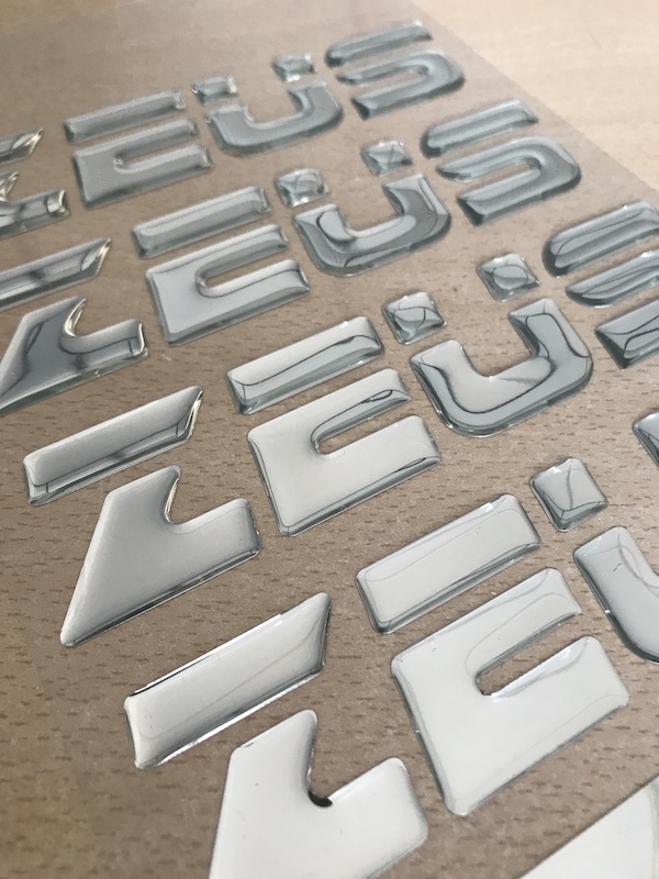 resinado de adhesivos con textos en material plateado